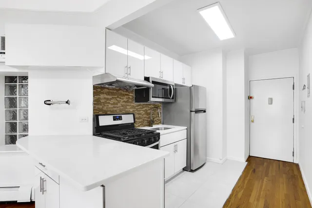 a view of kitchen with wooden floor and chairs