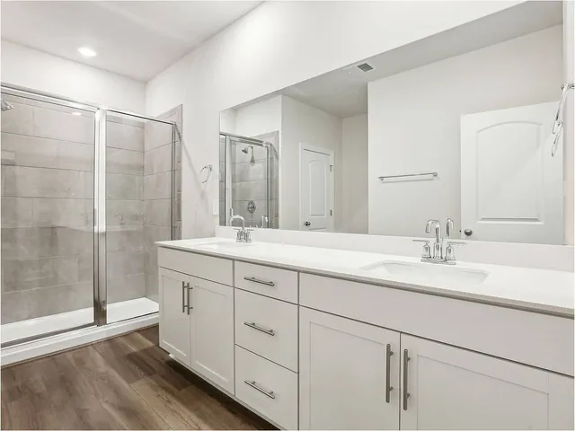 a bathroom with double sink and a mirror