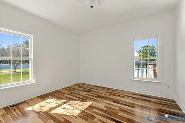 a view of a bedroom with wooden floor and a window