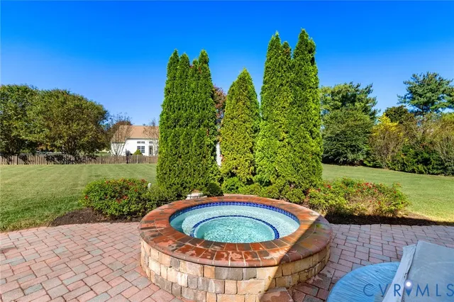 a view of a backyard with plants and a fountain