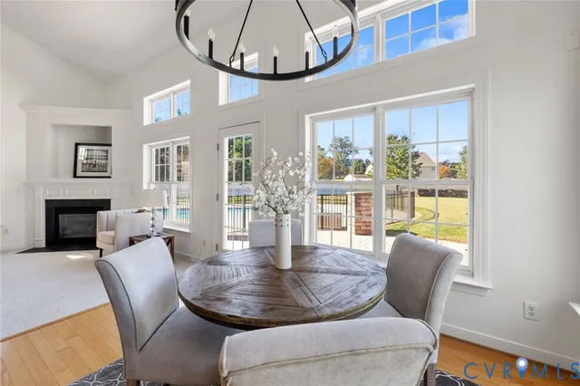 a dining room with furniture a fireplace and wooden floor