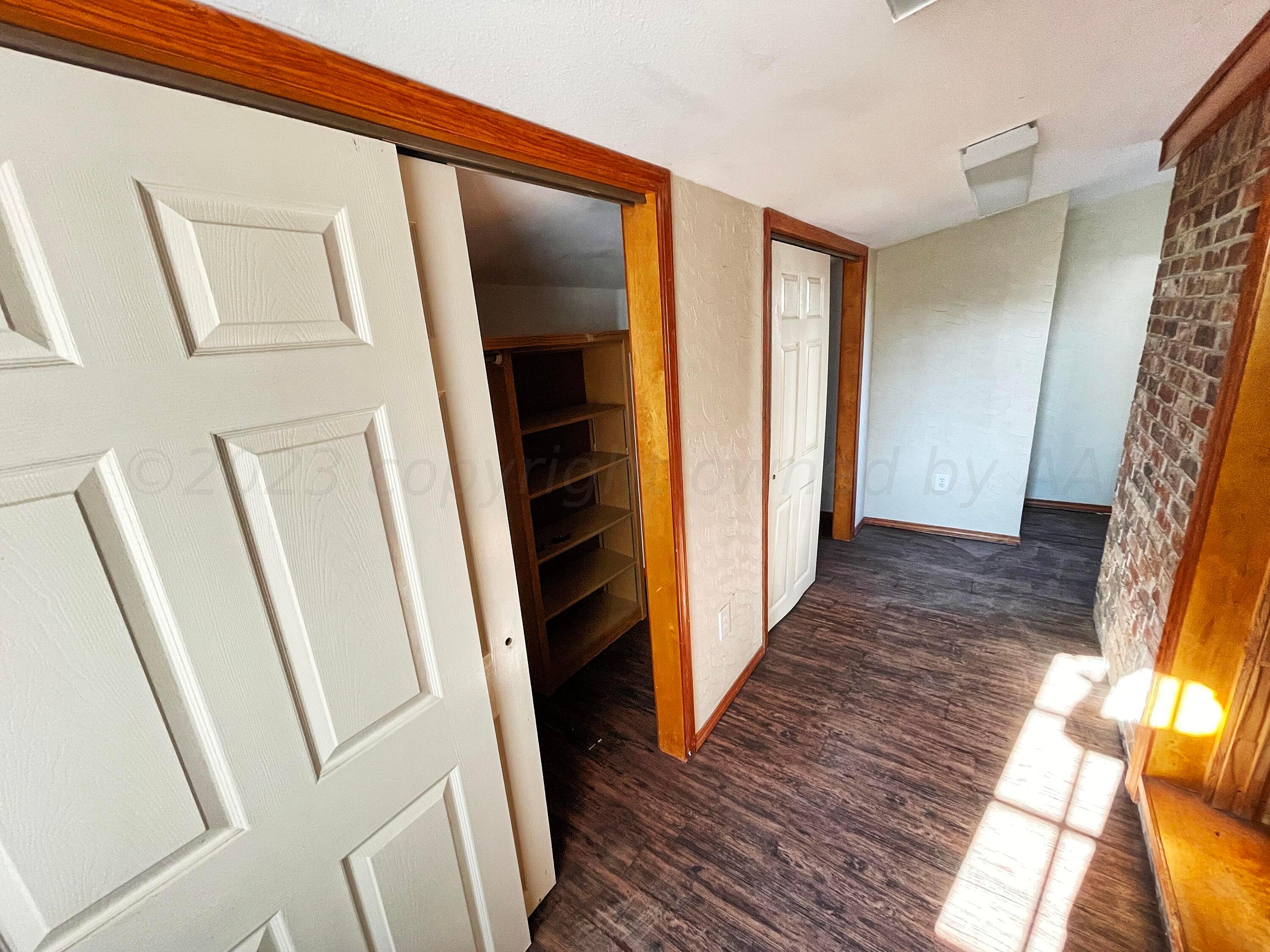 415 Southwest 5th Avenue Perryton, TX 79070 - Photo 14 of 16 a view of a hallway with wooden floor and staircase