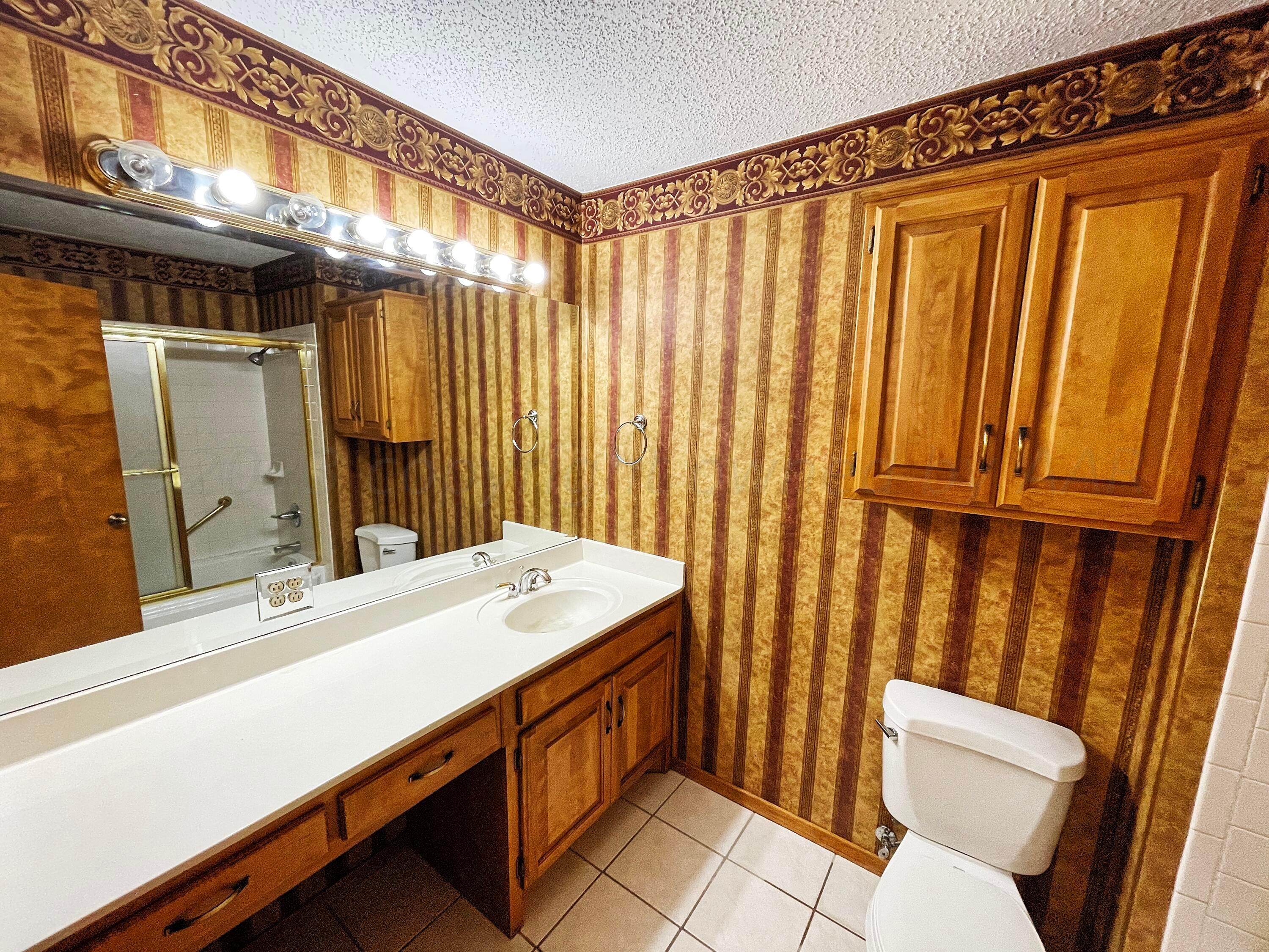 415 Southwest 5th Avenue Perryton, TX 79070 - Photo 7 of 16 a bathroom with a sink a toilet and shower