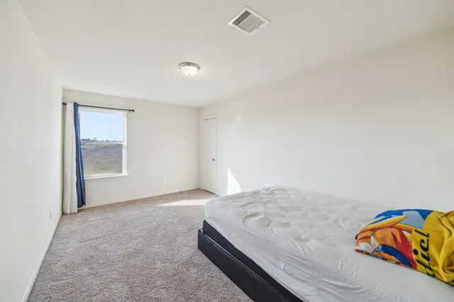 a bedroom with a bed and a window