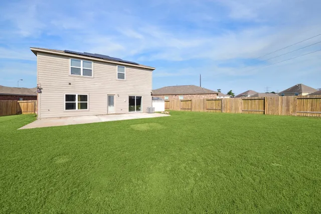 a view of a house with a big yard and large trees