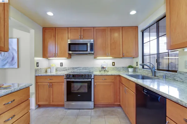 a kitchen with kitchen island granite countertop a sink stove and microwave