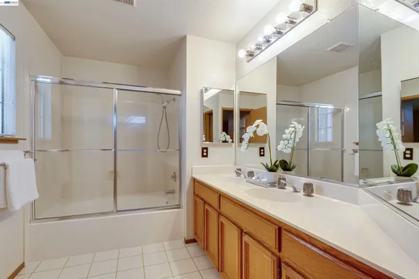 a bathroom with a shower sink and mirror