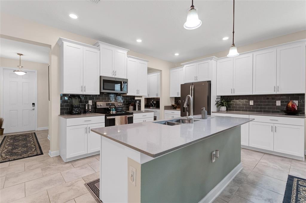 1089 Blackwolf Run Road Davenport, FL 33896 - Photo 8 of 82 a kitchen with a sink a white cabinets and stainless steel appliances