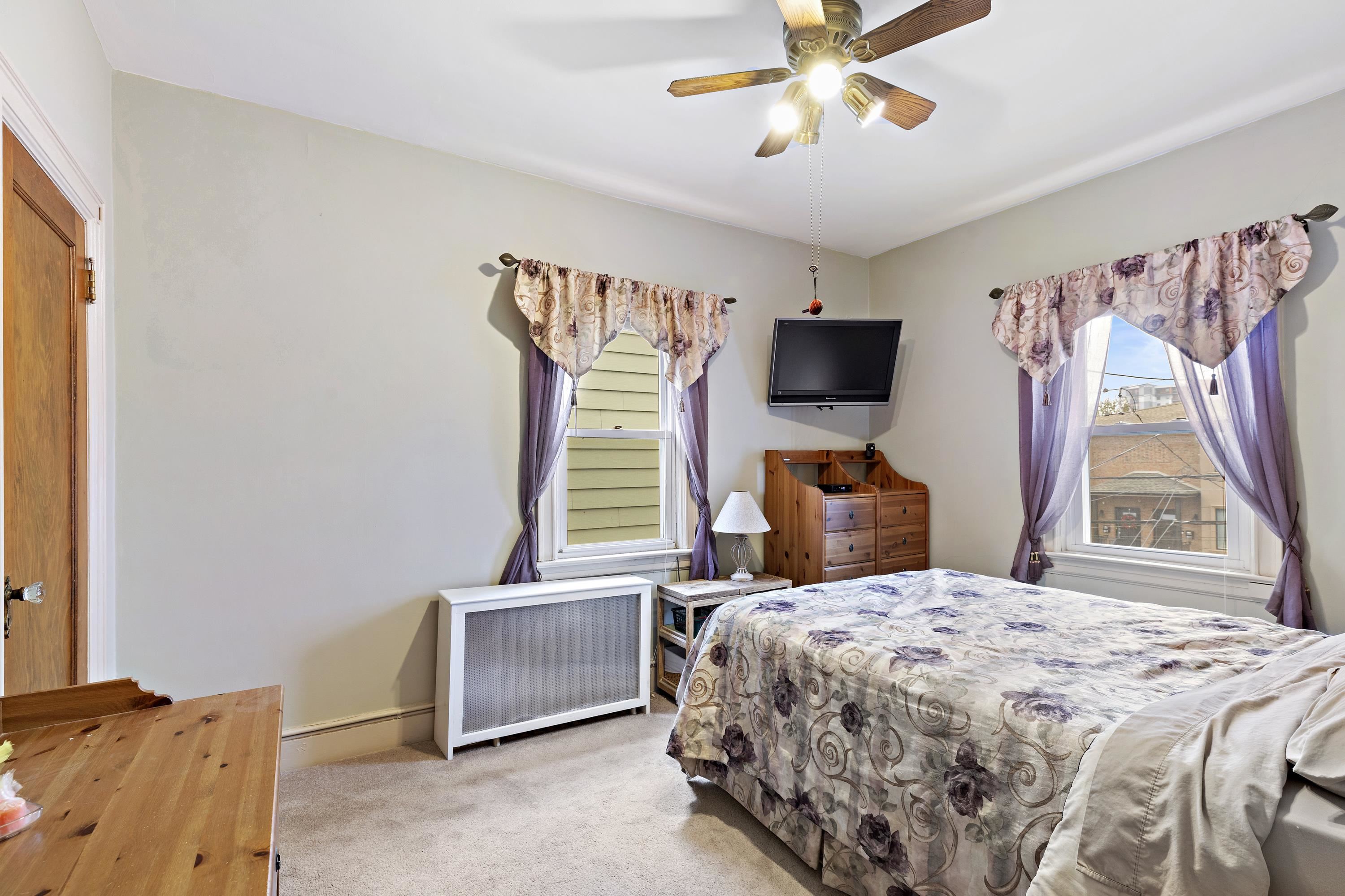 414 North 8th Street Fairview, NJ 07022 - Photo 13 of 22 a bedroom with a bed and a flat screen tv