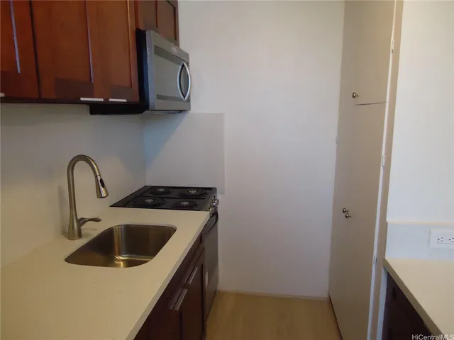 a view of a kitchen with sink and cabinets