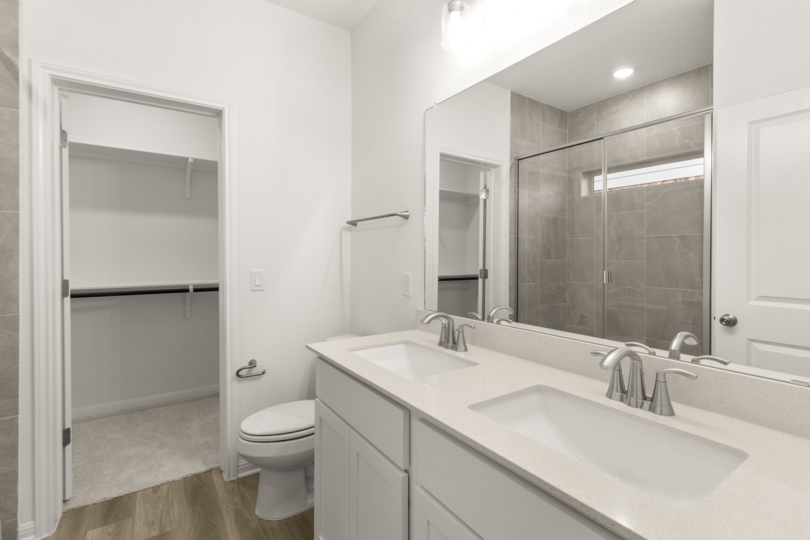 18605 Emu Lane Manor, TX 78653 - Photo 21 of 27 The bathroom features a double vanity with stone countertops, a large mirror, and a shower with a glass enclosure and tiled walls