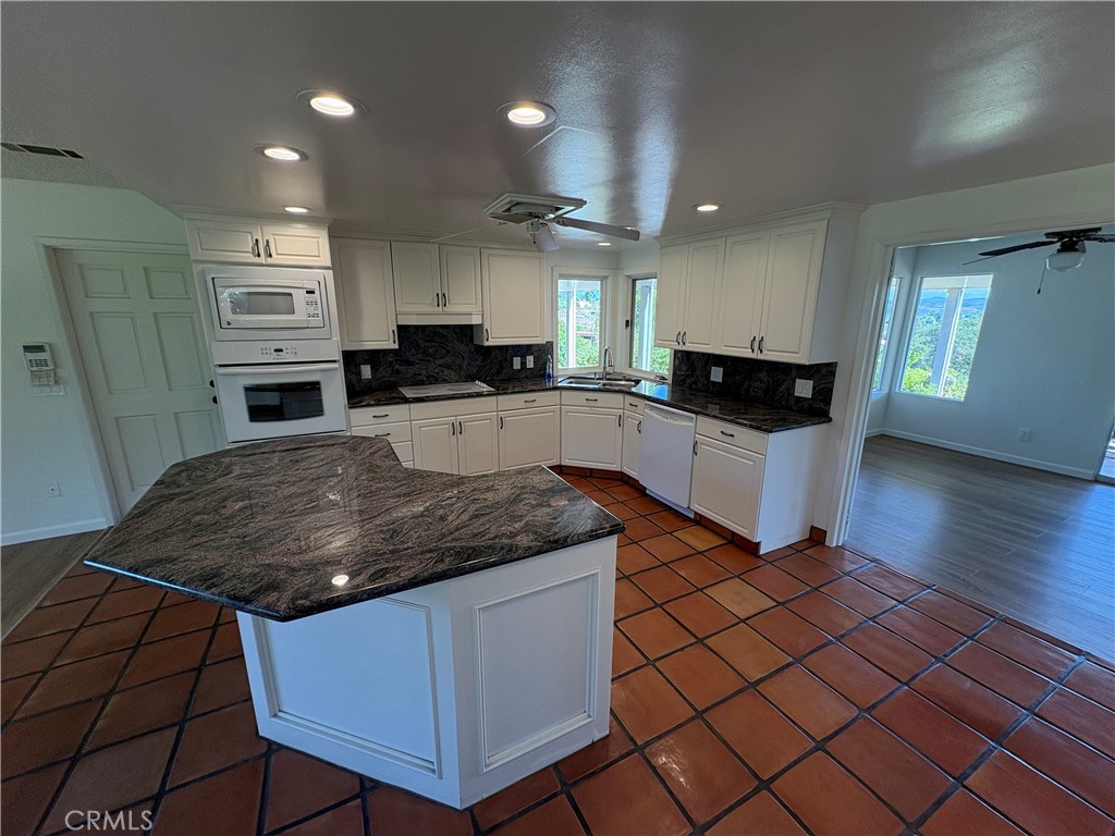 1905 Vista Del Norte Fallbrook, CA 92028 - Photo 4 of 29 a kitchen with stainless steel appliances kitchen island granite countertop a stove a sink and a microwave