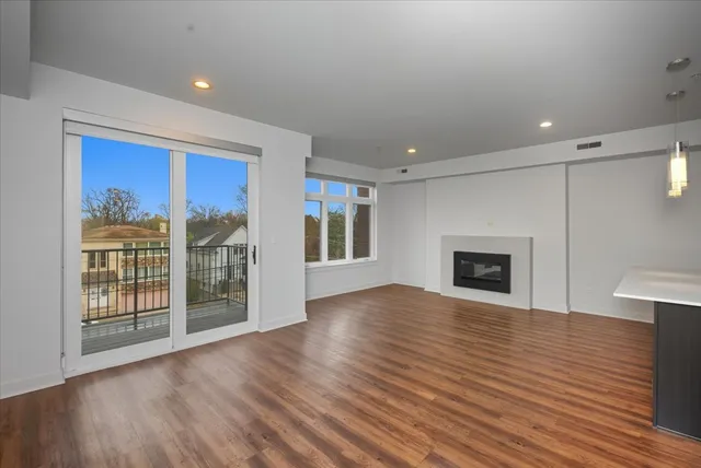 a view of empty room with wooden floor and fireplace