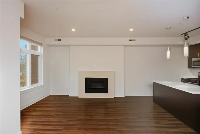 a view of empty room with wooden floor and fireplace