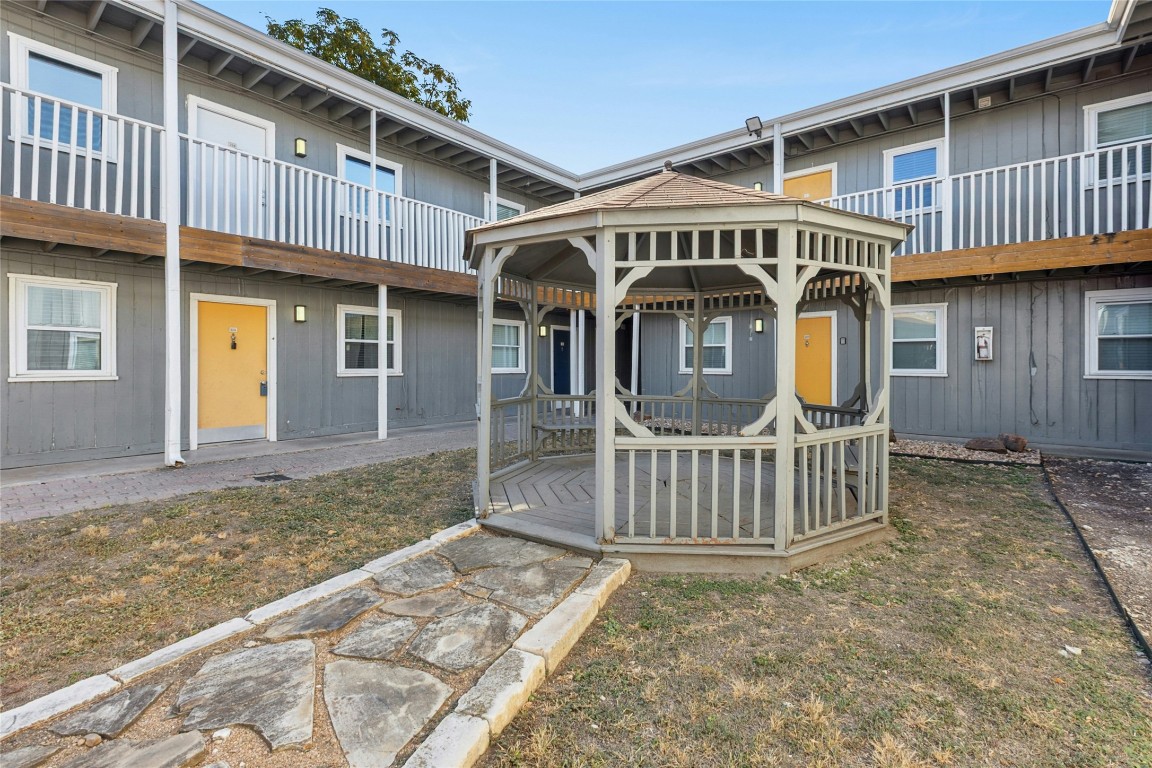 2401 Manor Road, Unit 214 Austin, TX 78722 - Photo 26 of 30 View of front facade featuring a wooden deck, a gazebo, a front lawn, and a balcony