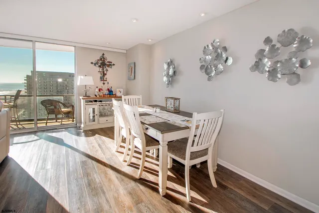 a view of a dining room with furniture a chandelier and wooden floor