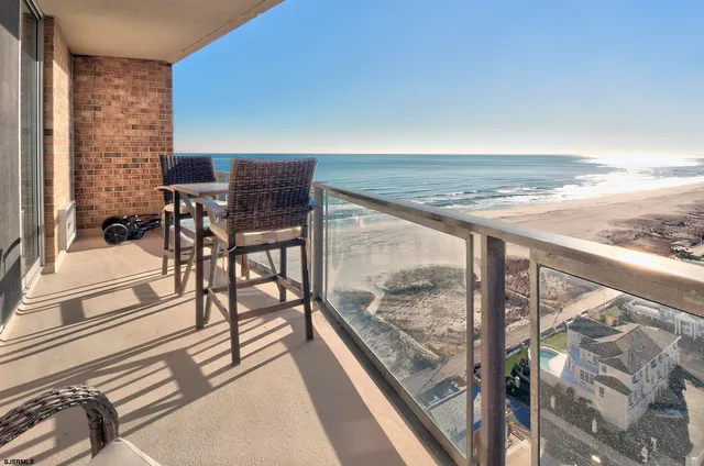 a view of a balcony with chairs and wooden floor