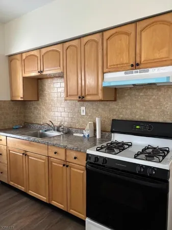 a kitchen with stainless steel appliances granite countertop a sink stove and cabinets
