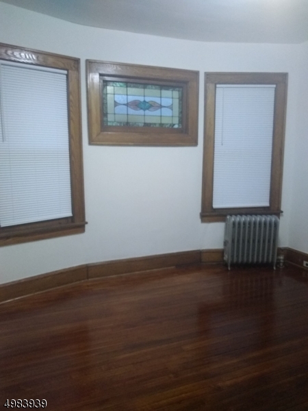 931 Madison Avenue Elizabeth, NJ 07201 - Photo 5 of 23 a view of an empty room with wooden floor and a window