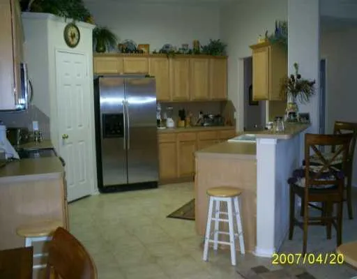 a kitchen with cabinets and chair