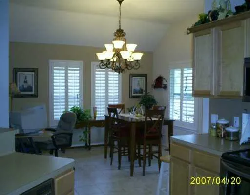 a living room with furniture a dining table and a chandelier