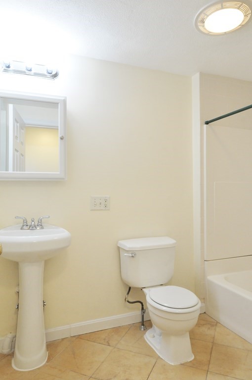 174 Maverick Street, Unit 3 Boston, MA 02128 - Photo 8 of 10 a bathroom with a sink a toilet and mirror