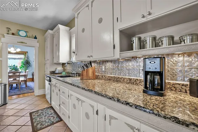 a kitchen with granite countertop a sink and cabinets
