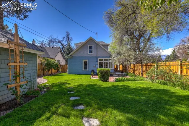 a view of a backyard with table and chairs and a barbeque