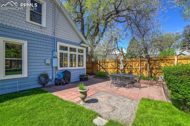 a view of backyard of house with outdoor seating and green space
