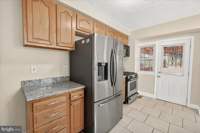 a kitchen with stainless steel appliances granite countertop a refrigerator and cabinets