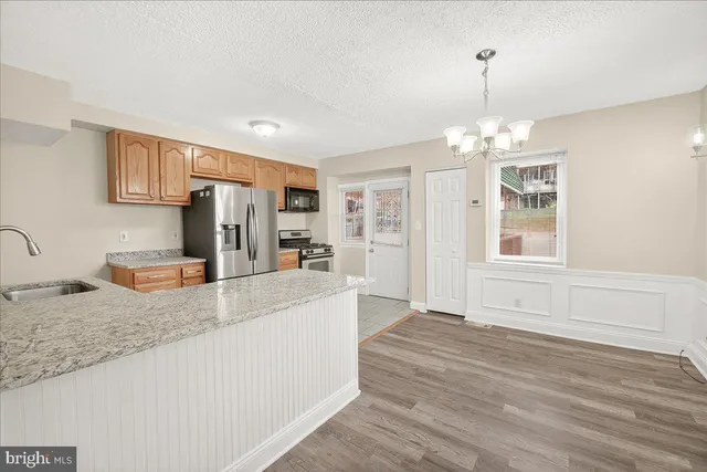 a large kitchen with kitchen island granite countertop a refrigerator and a sink