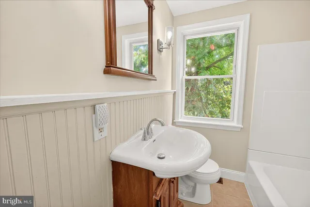a bathroom with a sink a toilet and a window