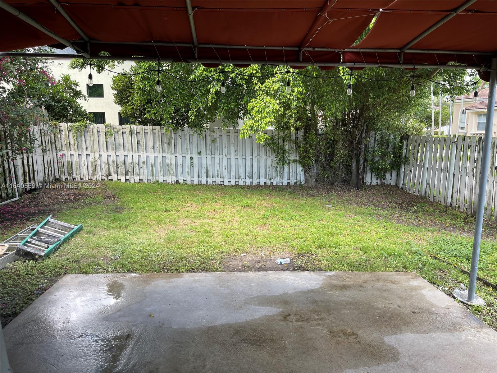 23852 Southwest 109th Place Homestead, FL 33032 - Photo 17 of 19 a view of a backyard with table and chairs under an umbrella