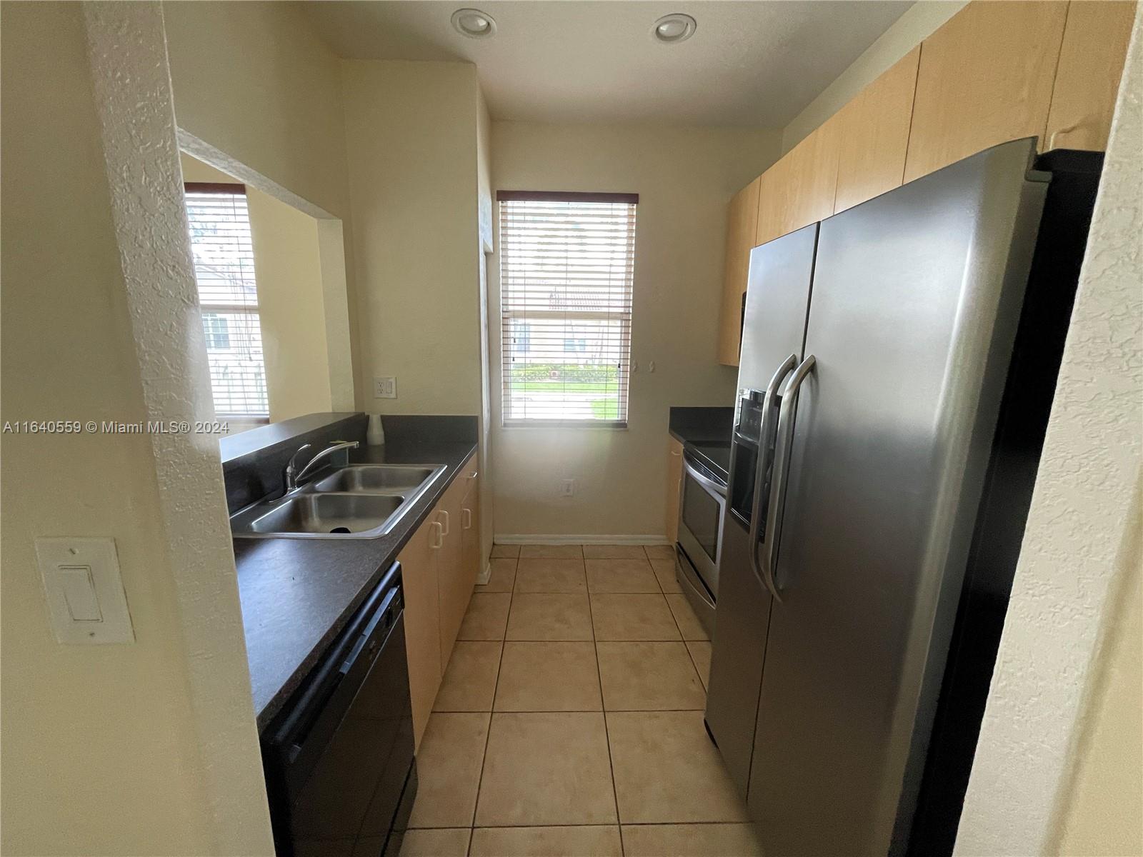 23852 Southwest 109th Place Homestead, FL 33032 - Photo 6 of 19 a kitchen with a refrigerator a sink and a window