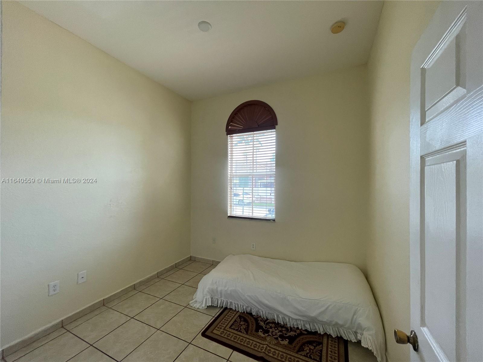 23852 Southwest 109th Place Homestead, FL 33032 - Photo 7 of 19 a bedroom with a bed and window
