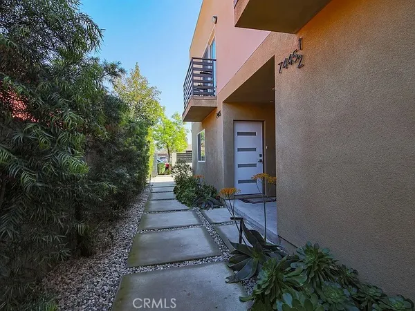 a view of a pathway of a house with potted plants