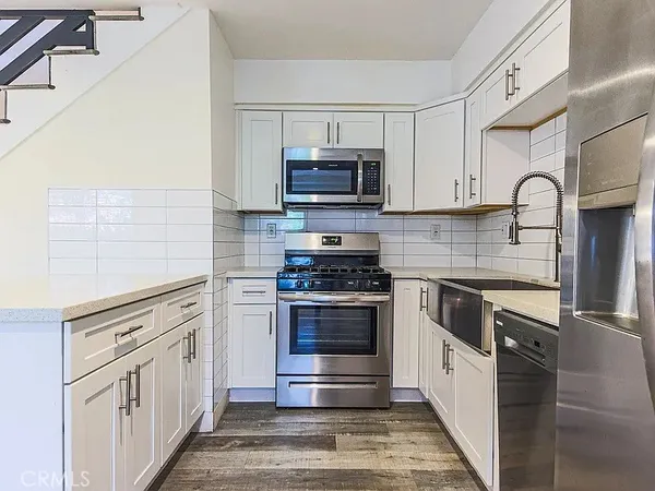 a kitchen with stainless steel appliances granite countertop a stove a sink and a microwave