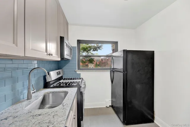 a kitchen with a refrigerator sink and cabinets