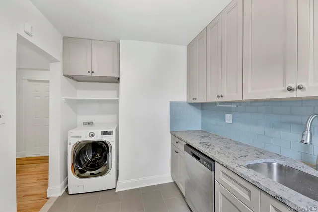 a utility room with sink dryer and washer