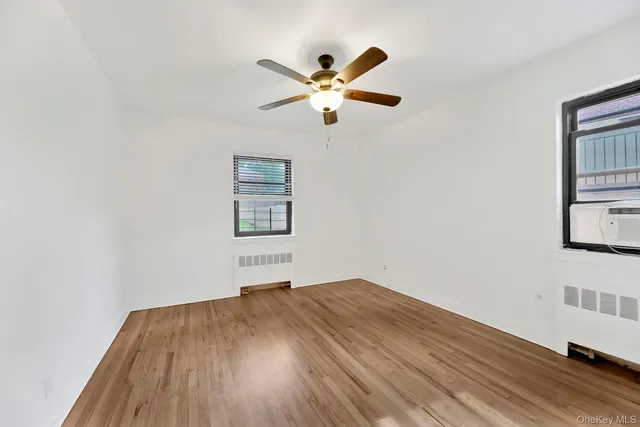 a view of a room with wooden floor and ceiling fan