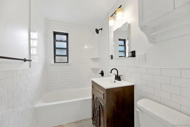 a bathroom with a sink mirror toilet and bathtub
