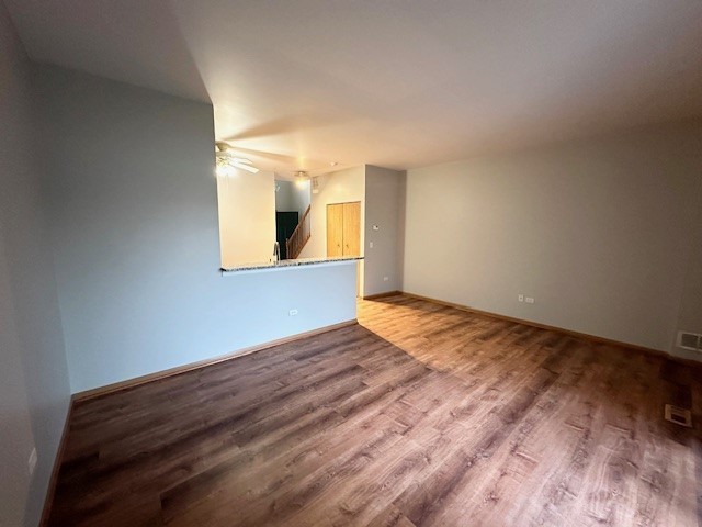 2446 Oak Tree Lane, Unit 2446 Plainfield, IL 60586 - Photo 2 of 11 a view of empty room with wooden floor and fan