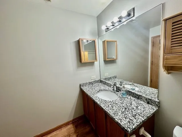 a bathroom with a granite countertop sink and a mirror