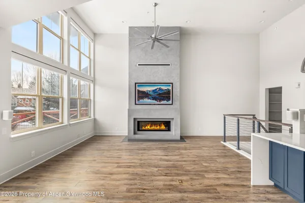 a view of an empty room with a window and fire place