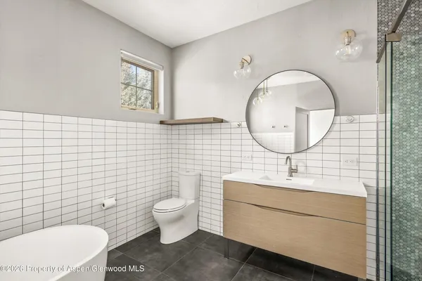 a bathroom with a toilet a sink and mirror