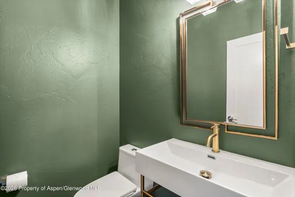 a bathroom with a sink a toilet and a mirror