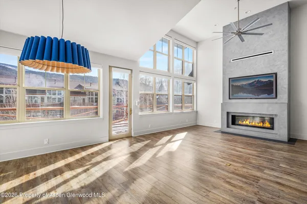a view of an empty room with glass door and wooden floor