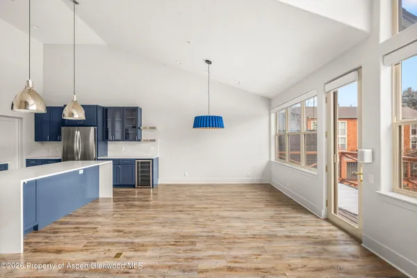 a kitchen with stainless steel appliances kitchen island granite countertop a sink a stove and a wooden floors