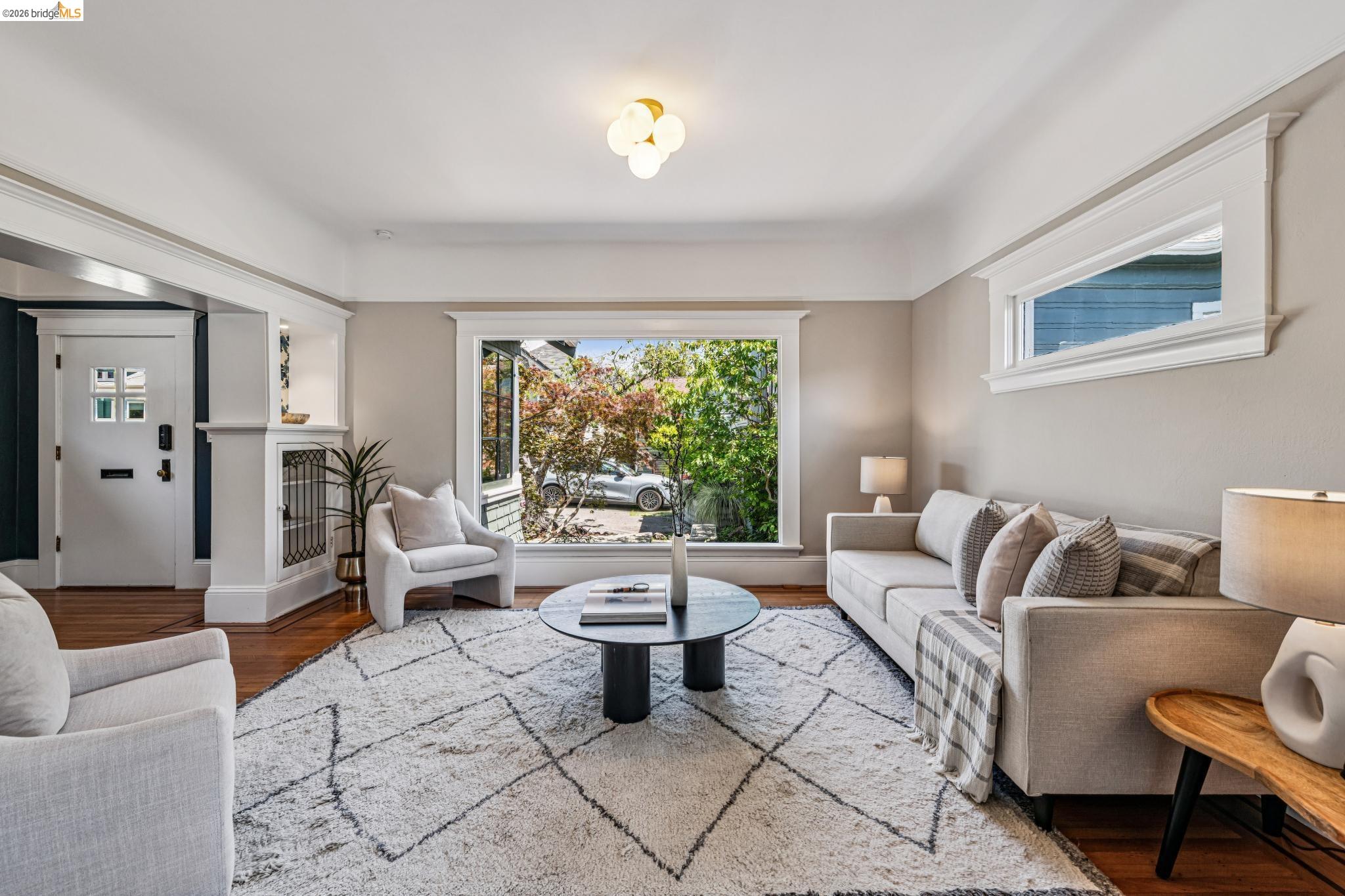 6521 Dover Street Berkeley, CA 94703 - Photo 13 of 80 Living area featuring wood-finish flooring, a large picture window, and a transom window