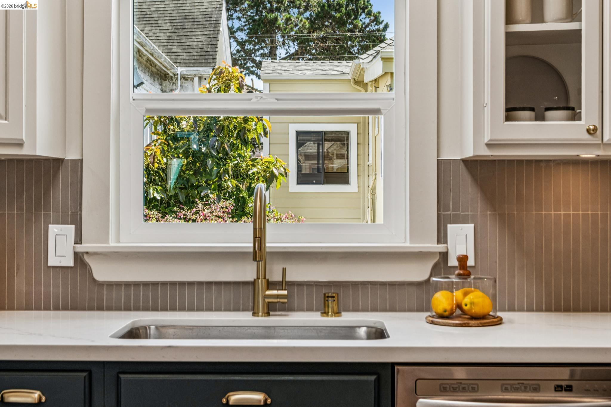 6521 Dover Street Berkeley, CA 94703 - Photo 22 of 80 Kitchen sink area featuring a single-handle gold-tone faucet, under-mount stainless steel sink, and light-toned countertop